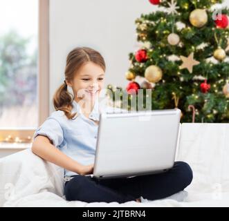 girl with laptop computer at home on christmas Stock Photo