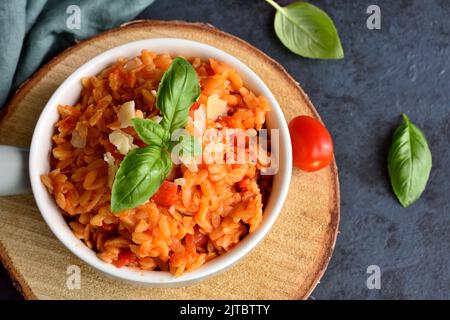 Kritharaki with tomatoes and chicken. Traditional type of Greek pasta shape of rice. Greek version of Italian Orzo Stock Photo