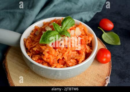 Kritharaki with tomatoes and chicken. Traditional type of Greek pasta shape of rice. Greek version of Italian Orzo Stock Photo