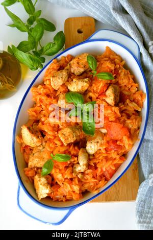 Kritharaki with tomatoes and chicken. Traditional type of Greek pasta shape of rice. Greek version of Italian Orzo Stock Photo