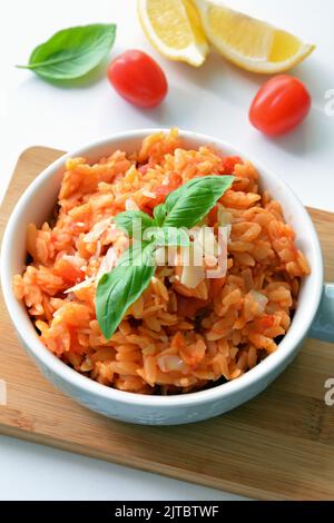 Kritharaki with tomatoes and chicken. Traditional type of Greek pasta shape of rice. Greek version of Italian Orzo Stock Photo