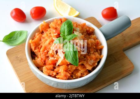 Kritharaki with tomatoes and chicken. Traditional type of Greek pasta shape of rice. Greek version of Italian Orzo Stock Photo