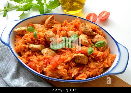 Kritharaki with tomatoes and chicken. Traditional type of Greek pasta shape of rice. Greek version of Italian Orzo Stock Photo