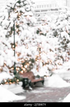 Beautiful blurred image of fir tree decorations and lights of traditional Christmas fair. Holidays concept. Winter holiday season background. Stock Photo
