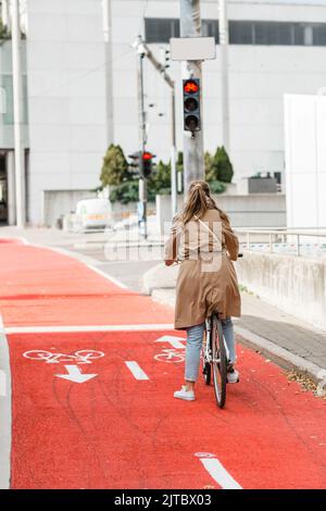 woman on bicycle waiting for green traffic light Stock Photo