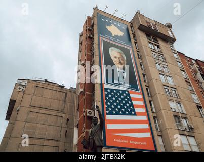 A low-angle shot of Bill Clinton banner and statue in downtown Pristina Stock Photo