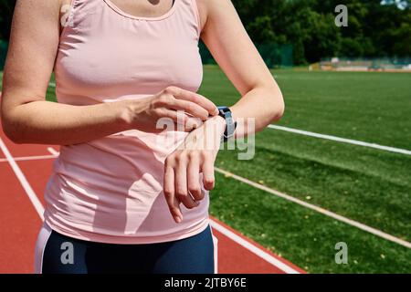 Woman use fitness watch before cardio exercises, Checking results on smart watch after training, Healthy lifestyle concept Stock Photo