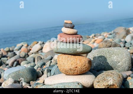 Colorful stones are naturally balanced on the background of the sea. Stock Photo