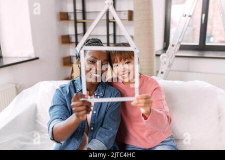 happy smiling women with ruler in shape of house Stock Photo