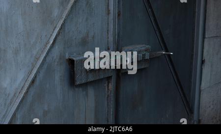 Side view of the deadbolt of an old gray metal gate. The bolt is closed. Traces of corrosion on metal. Aging process. Rust. Home security. Outdoors. Stock Photo