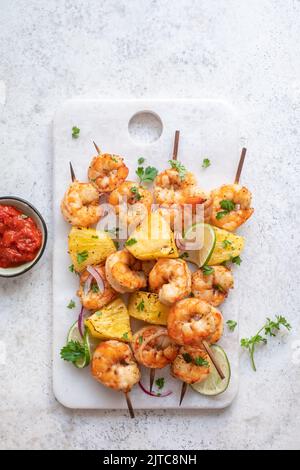 skewers of barbecued shrimp with a pineapple Stock Photo