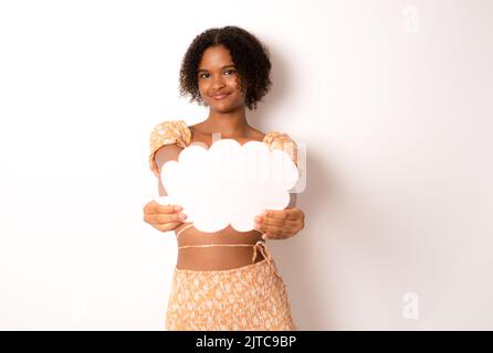 Close up photo of funny pretty dark skin lady holding paper cloud mind thinking over creative dialogue answer doubtful in casual clothing isolated whi Stock Photo