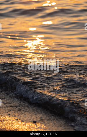 Ripple sea ocean water surface with golden sunset light. Sea wave close up Stock Photo