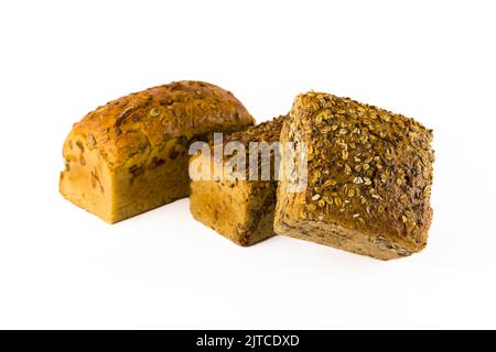 Three whole wheat loaves of bread with different toppings - pumpkin seeds, sunflower seeds, and mixed oats and sunflower seeds. Isolated on white background. Baking advertisement concept. High quality photo Stock Photo