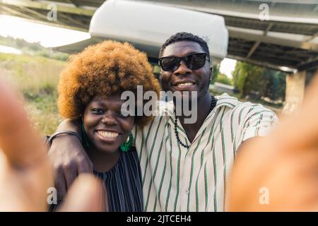 Afro-American woman and man smiling and taking a selfie, outdoors medium closeup. High quality photo Stock Photo