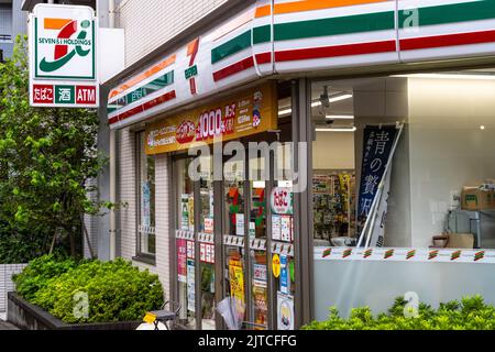 A 7-Eleven Store, one of thousands of convenience stores across, Tokyo, Japan. The 7-Eleven neighborhood convenience stores originated in Texas, but became a Japanese company in 1991 with nearly 79,000 stores across nineteen countries. Stock Photo