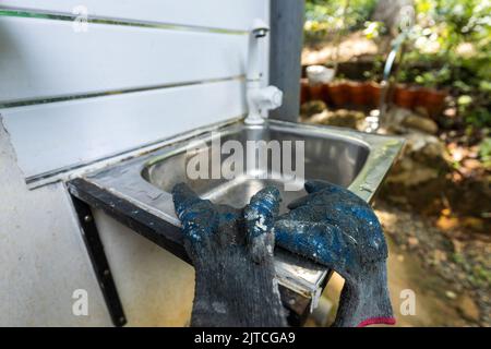 Gloves left unintentionally on a sink after washing hands. Bad practice. Stock Photo