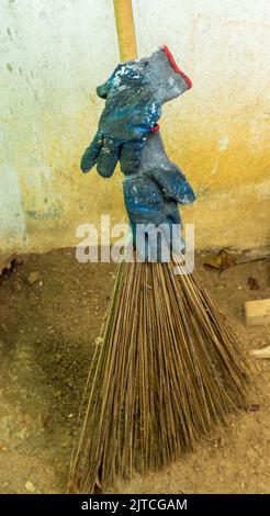 Gloves left unintentionally on a broom after work. Bad practice. Stock Photo