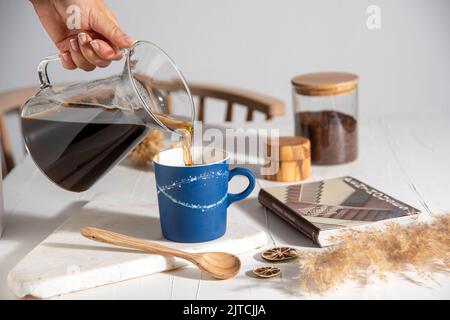 ceramic coffee cup with coffee drip pouring over Stock Photo