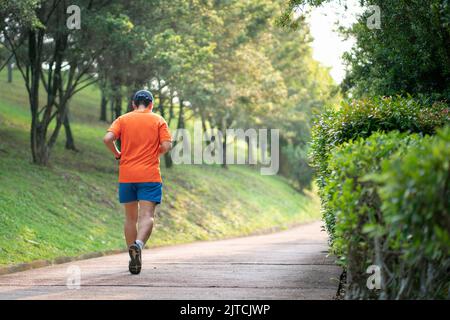 Man runner jogging on an outdoor path during sunset. Healthy lifestyle concept. Stock Photo