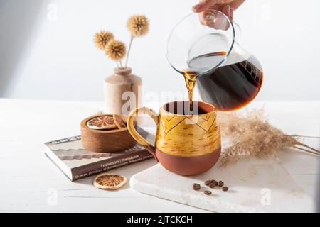 ceramic coffee cup with coffee drip pouring over Stock Photo