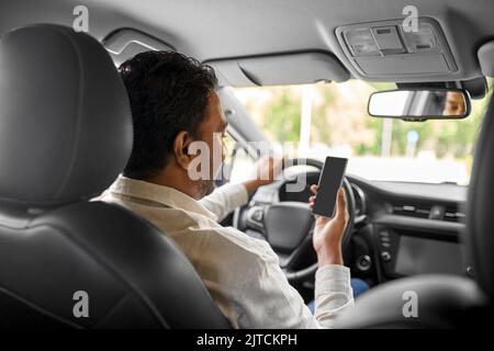 smiling indian man in car using smartphone Stock Photo