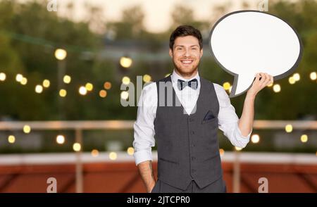 man in suit with text bubble at rooftop party Stock Photo
