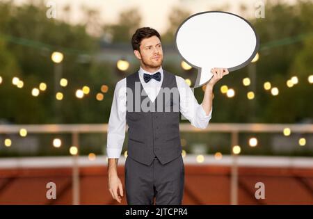 man in suit with text bubble at rooftop party Stock Photo