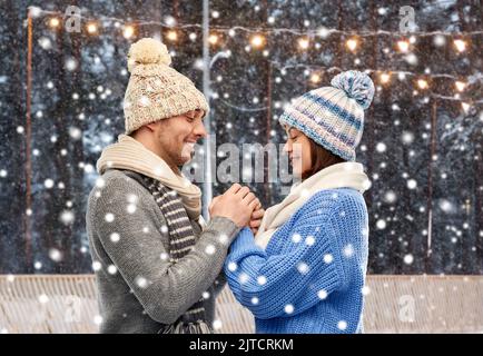 happy couple in winter clothes holding hands Stock Photo