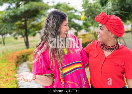 Two multi-ethnic women meet on a city street for a walk and talk. Stock Photo