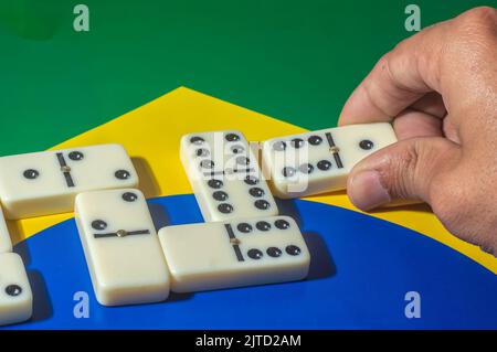 Domino game on top of a yellow and blue green flag,Brazilian colors,copy space. Stock Photo