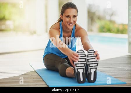 Stretching comes first. Portrait of an attractive young woman stretching before her workout. Stock Photo