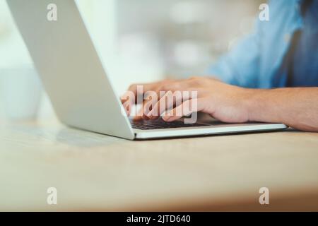 Letting his fingers do the talking. an unrecognizable man using his laptop at home. Stock Photo