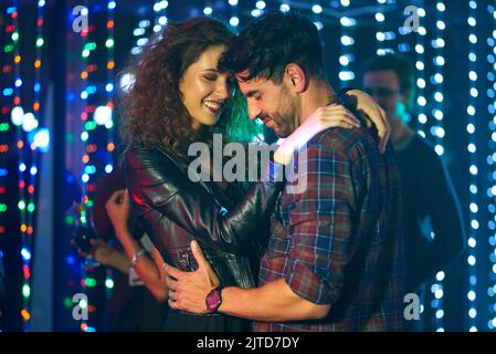 We love the nightlife. an affectionate young couple dancing together in a nightclub. Stock Photo
