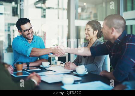 Glad to have you on board. two businessmen shaking hands during a meeting. Stock Photo