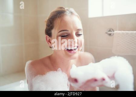 Bubble baths are my perfect kind of stress reliever. an attractive young woman relaxing in the bathtub. Stock Photo