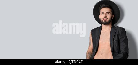 Handsome young tattooed man on light background with space for text Stock Photo