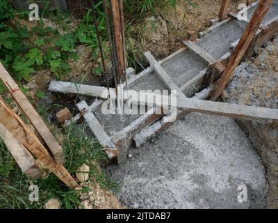 Filling reinforced beam with the concrete reinforcement frame, Timber formwork with metal reinforcement for pouring concrete Stock Photo