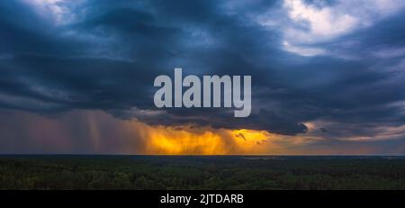 Storm cloud in the sunset light, aerial drone panorama of a storm Stock Photo