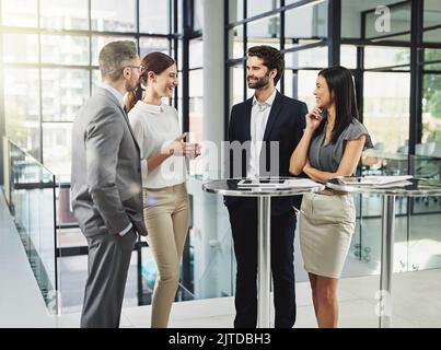 Theyre a team of over achievers. a group of colleagues discussing business in the office. Stock Photo
