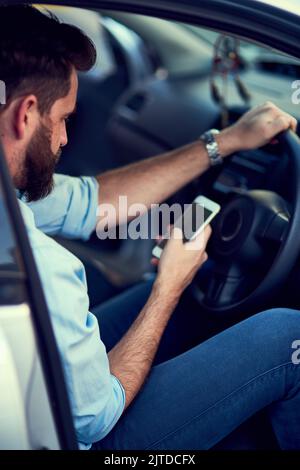 Navigating is easy when you have a phone. a unrecognizable man using his phone while driving to a destination. Stock Photo