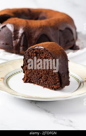 Slice of a dark chocolate bundt cake with chocolate ganache. Stock Photo