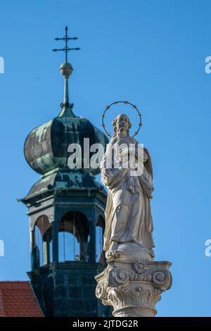 Religious statue with dome topped church Stock Photo