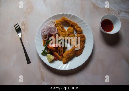 Top view of fried chicken wings along with condiments in a white plate. Stock Photo