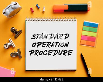 The word standard operation procedure sop written on a notebook on business desktop. Stock Photo