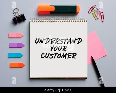 The message understand your customer written on a notebook on office desktop. Customer care in business concept. Stock Photo