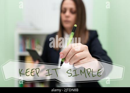 Sign displaying Keep It Simple. Business idea Easy to toss around Understandable Generic terminology Woman Typing Recent Update On Lap Top And Holding Stock Photo