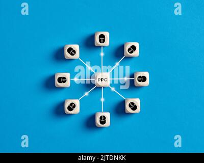 Pay per click PPC concept. Wooden cubes with mouse icons connected to the acronym PPC. Stock Photo