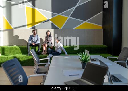 Colleagues spending time in the lounge zone in the office Stock Photo
