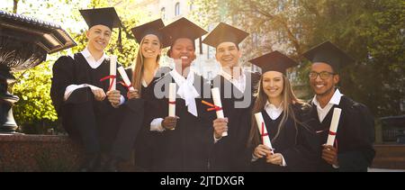 Joyful group of multiracial students who together received diploma of graduation and education. Stock Photo